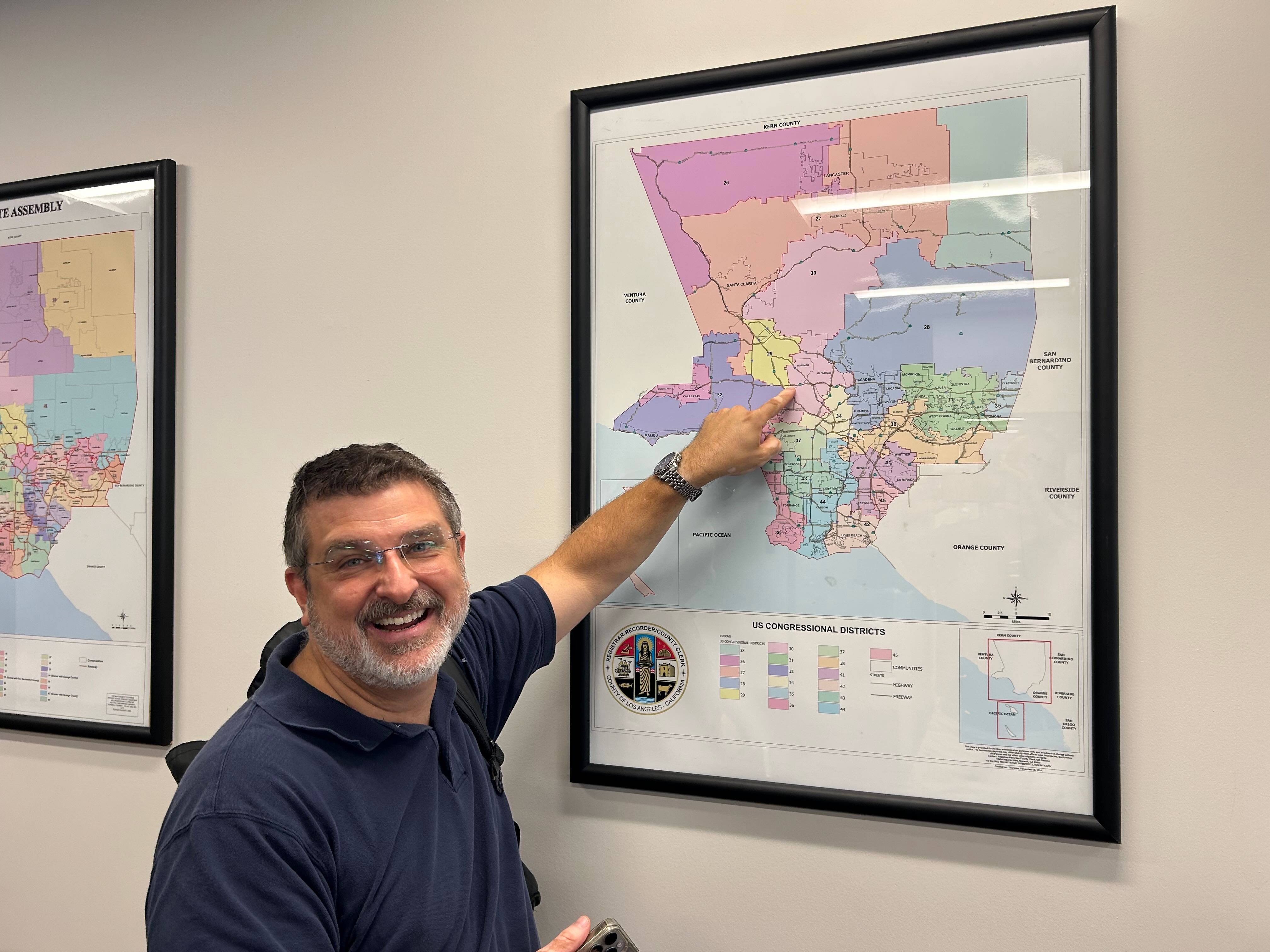 Paul pointing out Trustee Area 3 on the wall map at the L.A. County Election Office in Norwalk